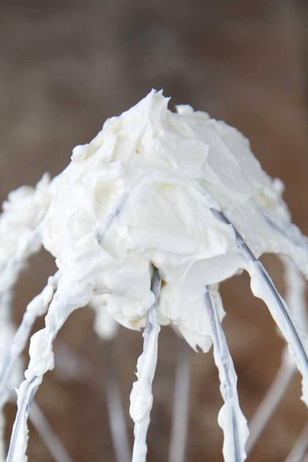 Swiss meringue buttercream on whisk closeup.