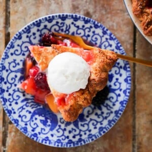 Peach Blackberry Pie on blue plate with ice cream