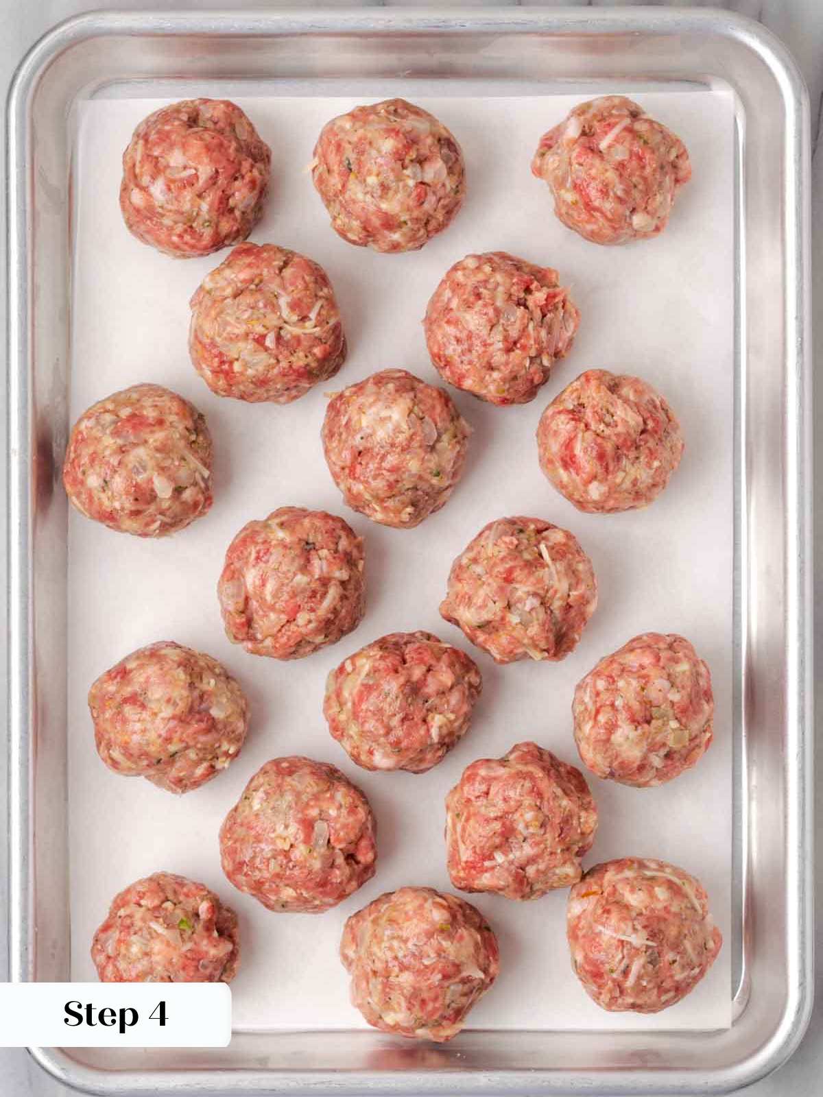 rolled raw meatballs on sheetpan.