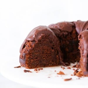 Chocolate Zucchini Cake fudge glaze sliced on cake stand