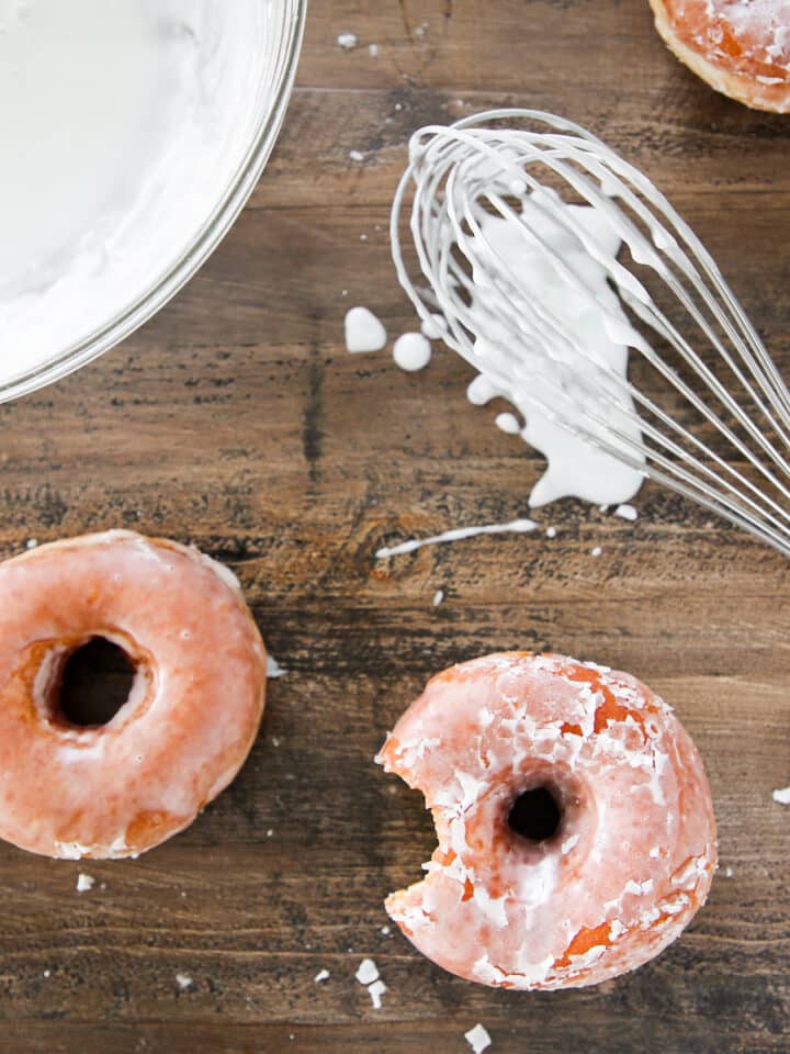 Classic Donut Glaze with yeasted donuts on wood board