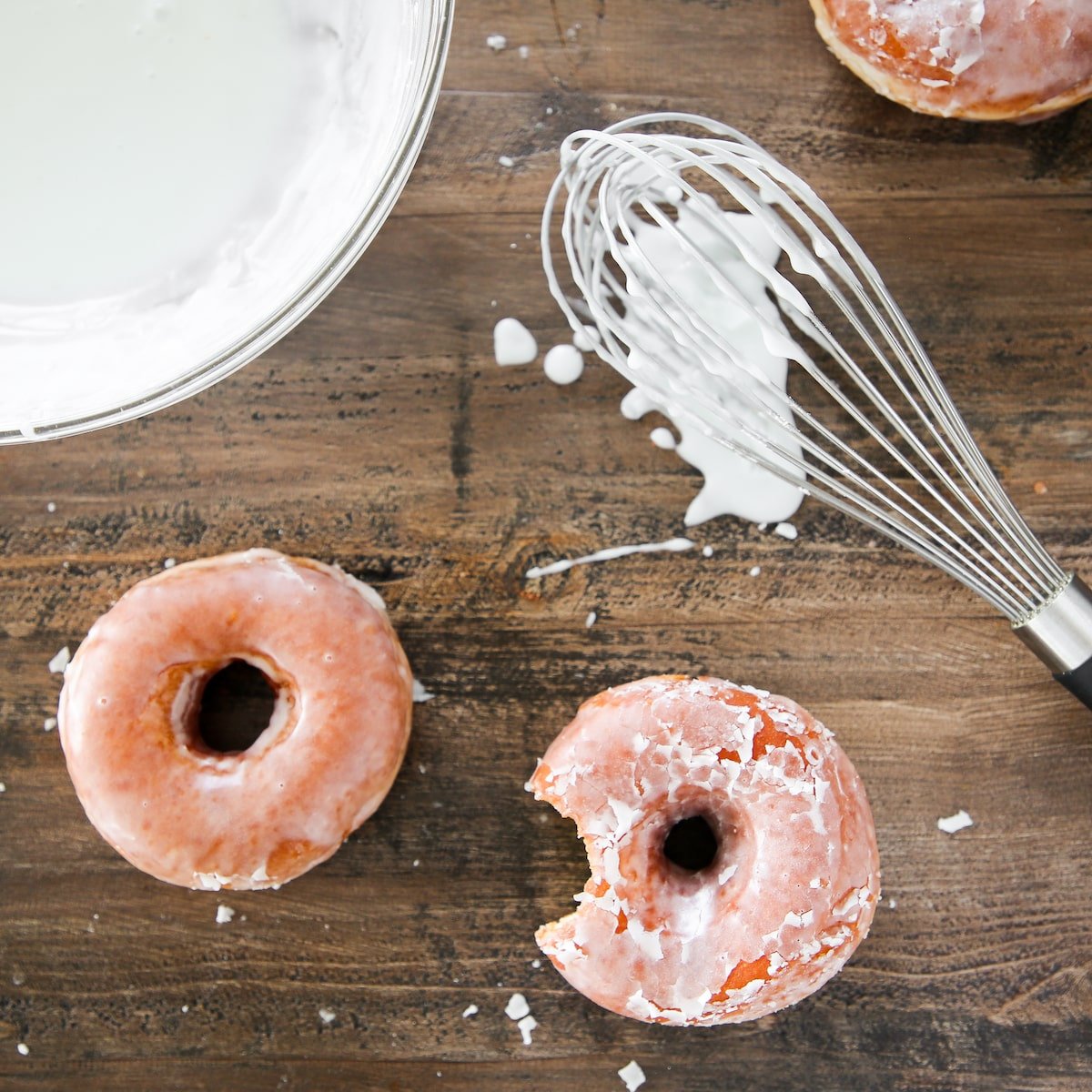 Classic Donut Glaze with yeasted donuts on wood board.