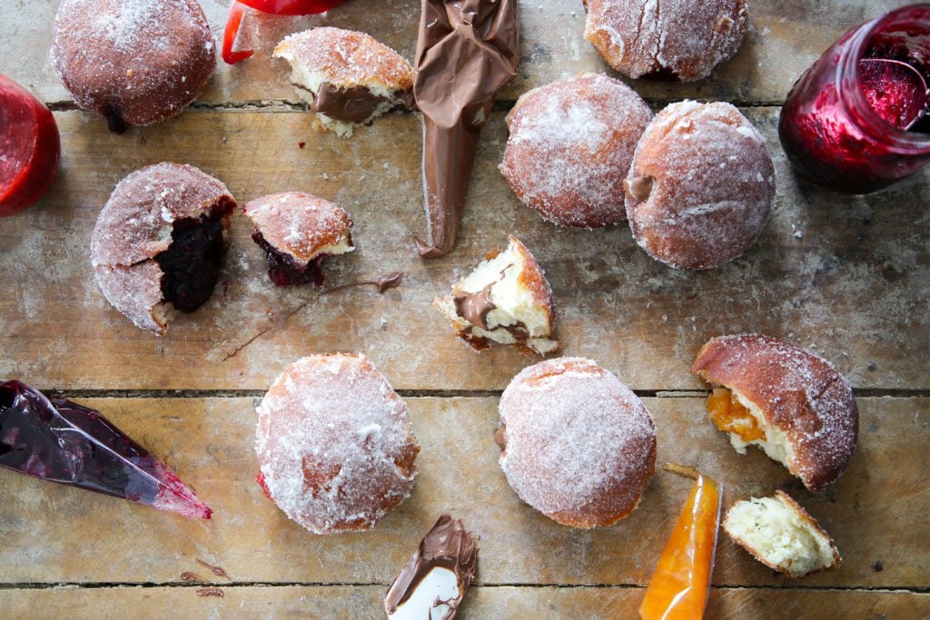 variety of donuts and fillings on a wood surface. 