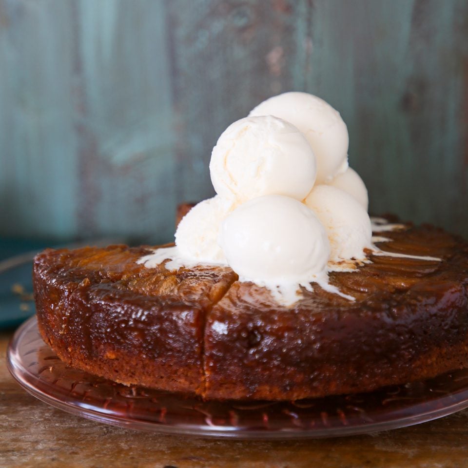 Pear upside down cake with scoops of vanilla ice cream on top.