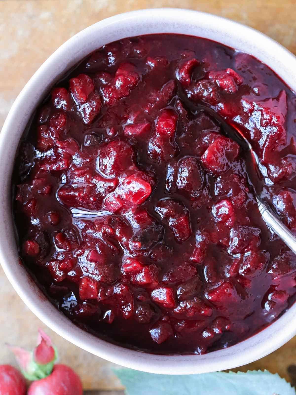 easy thanksgiving dinner recipe for cranberry chutney in bowl on wooden surface.
