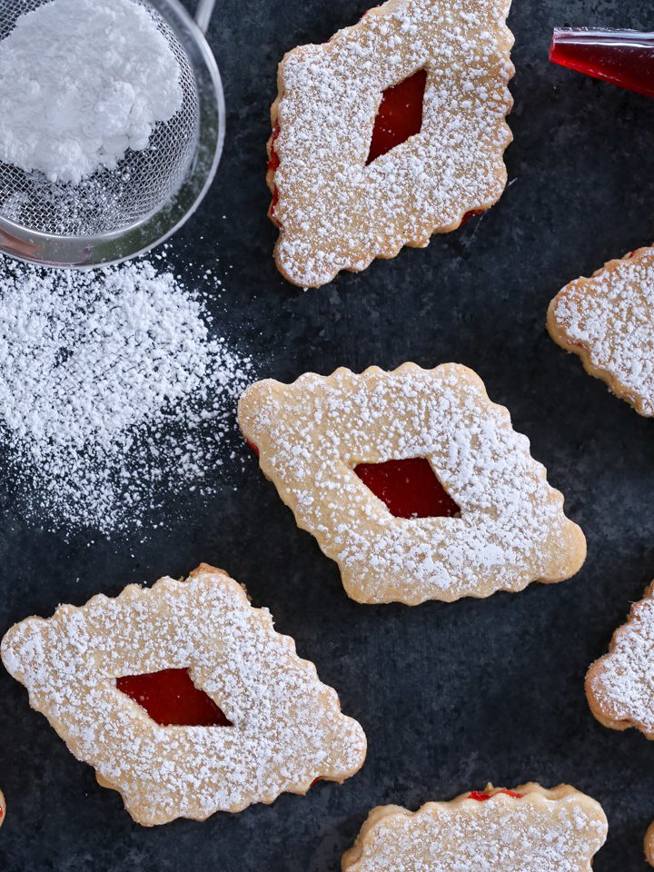 Diamond-shaped linzer cookies with red raspberry centers.