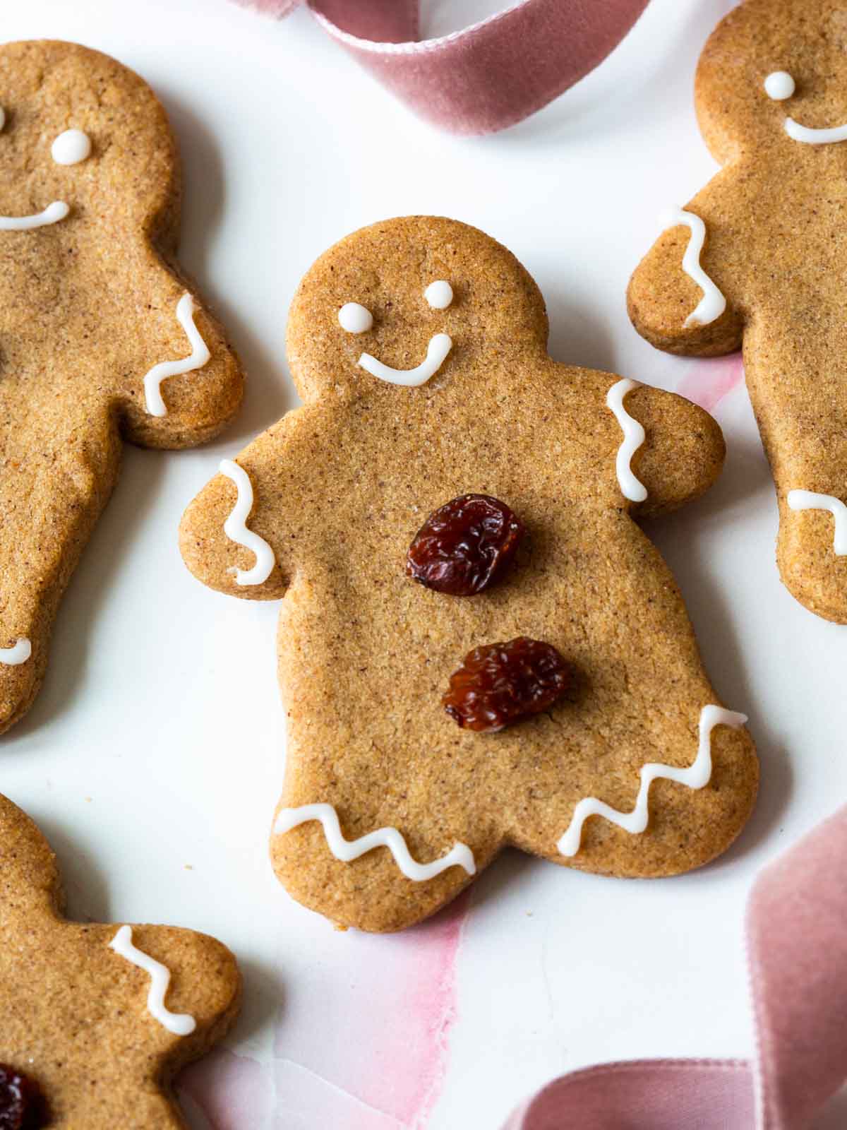 gingerbread cookie with white icing and raisins.