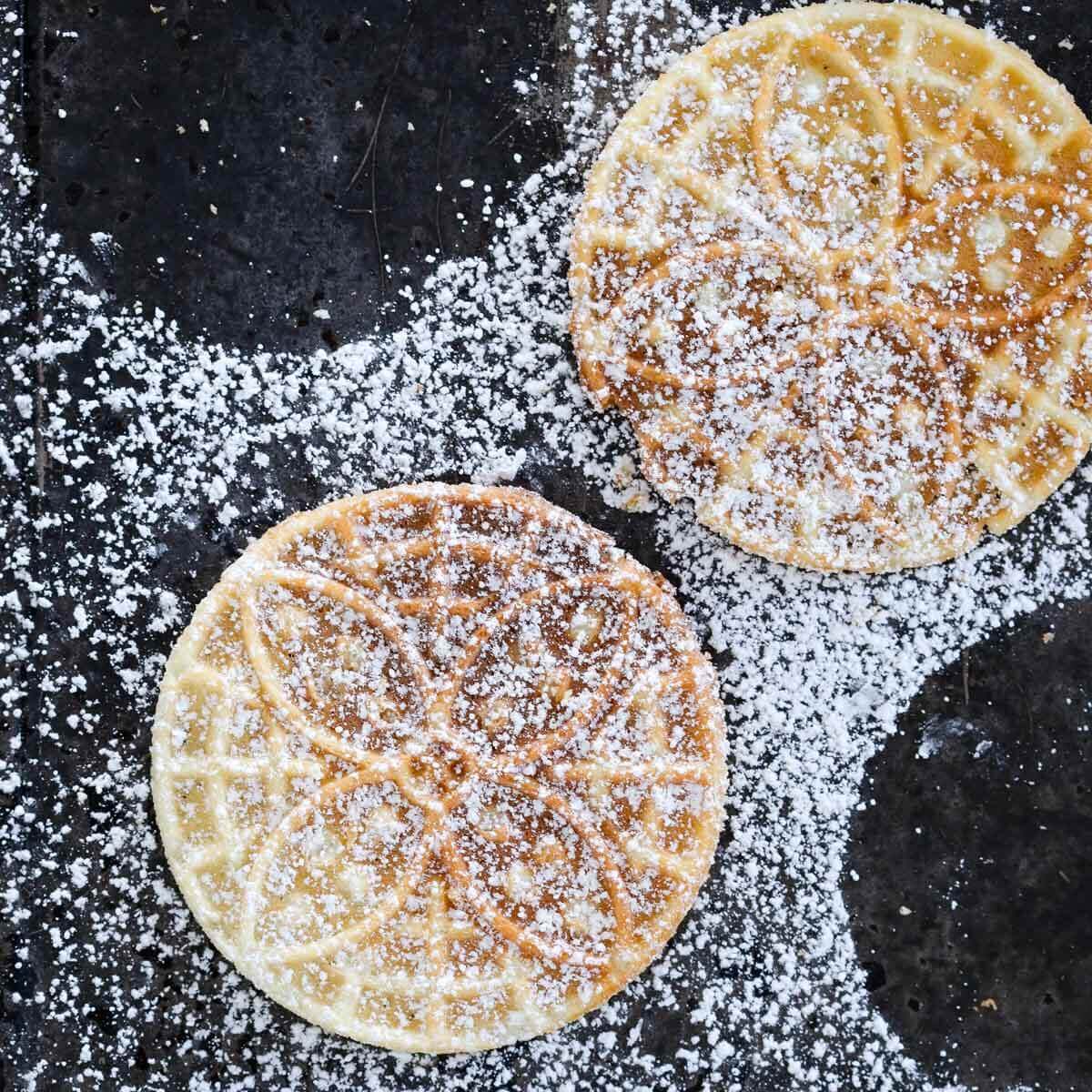 pizzelle cookies dusted with powdered sugar. 