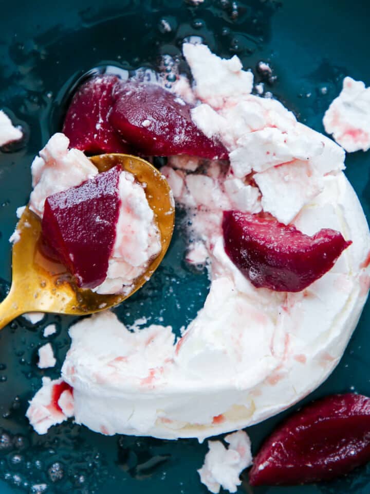 Red Wine Poached Pear Pavlova on green plate smashed