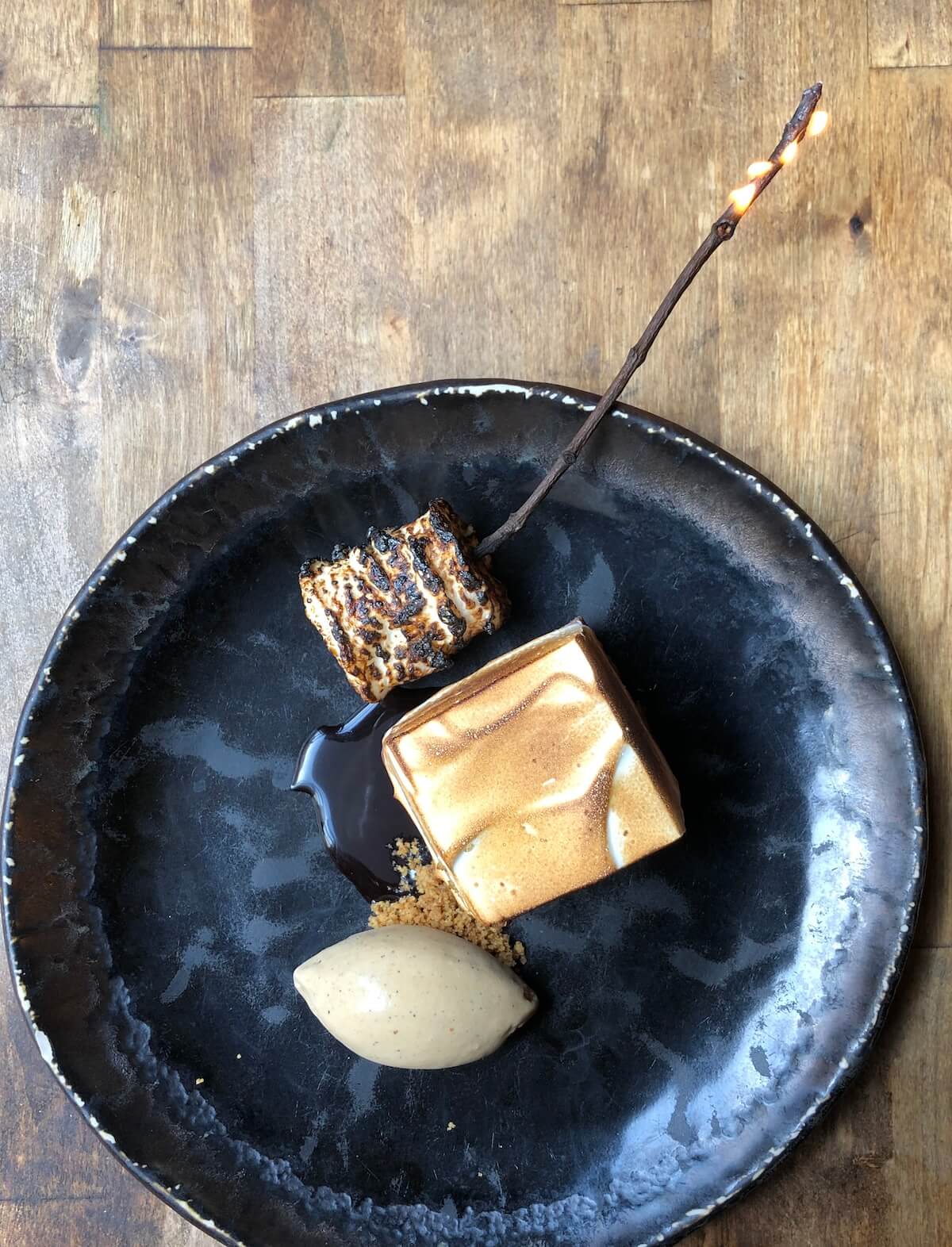 plated s'mores dessert on black plate.