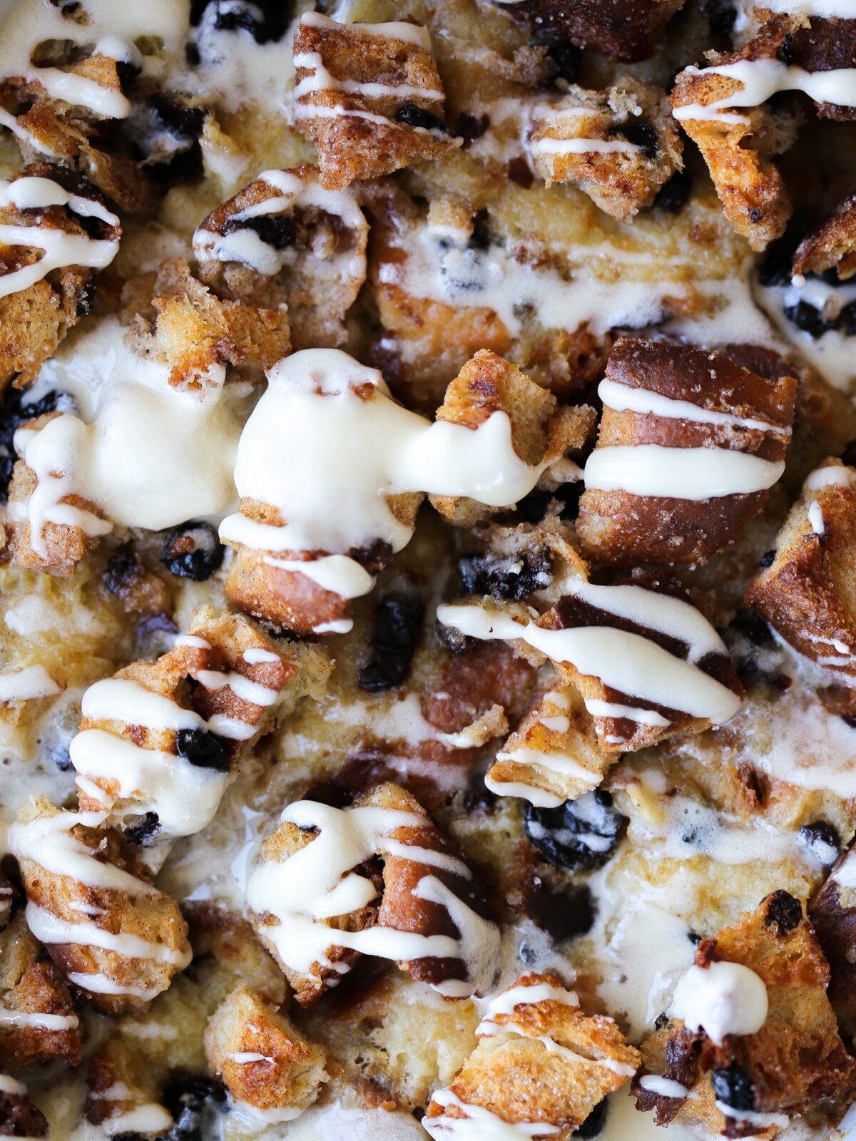 bread pudding with crunchy sugared topping and hard sauce in dish.