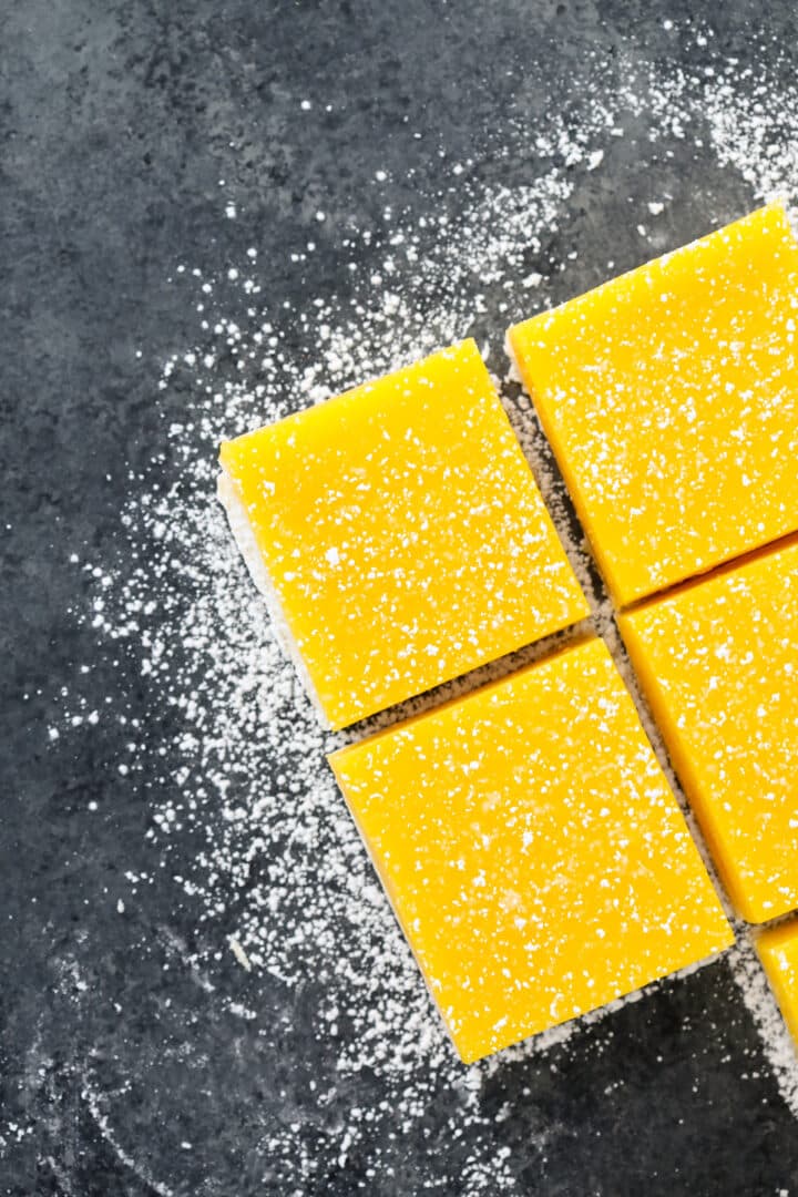 Lemon Bars Confectioners Sugar on Grey Board