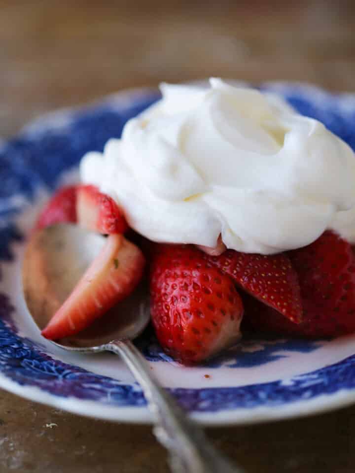 Lemon Whipped Cream on blue plate with strawberries close up