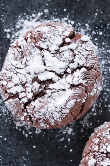 Chocolate Crackle Cookie with powdered sugar on black surface Easy Chocolate Desserts.