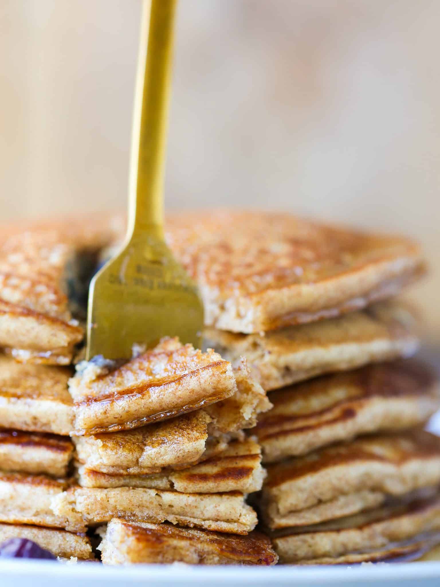Whole wheat pancakes stacked with a gold fork.