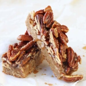 Maple Pecan Caramel Blondies leaning on parchment