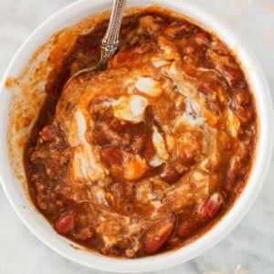 Pinot Noir Chili in bowl with sour cream and cheese.