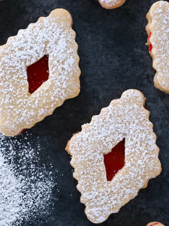 Raspberry Linzer Cookies on dark surface