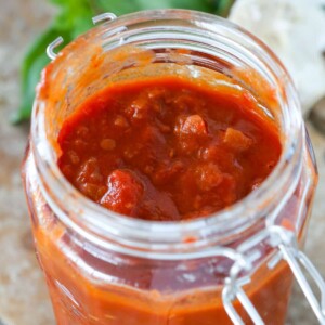 Red Wine Basil Pasta Sauce in a clear mason jar with the lid unlatched.