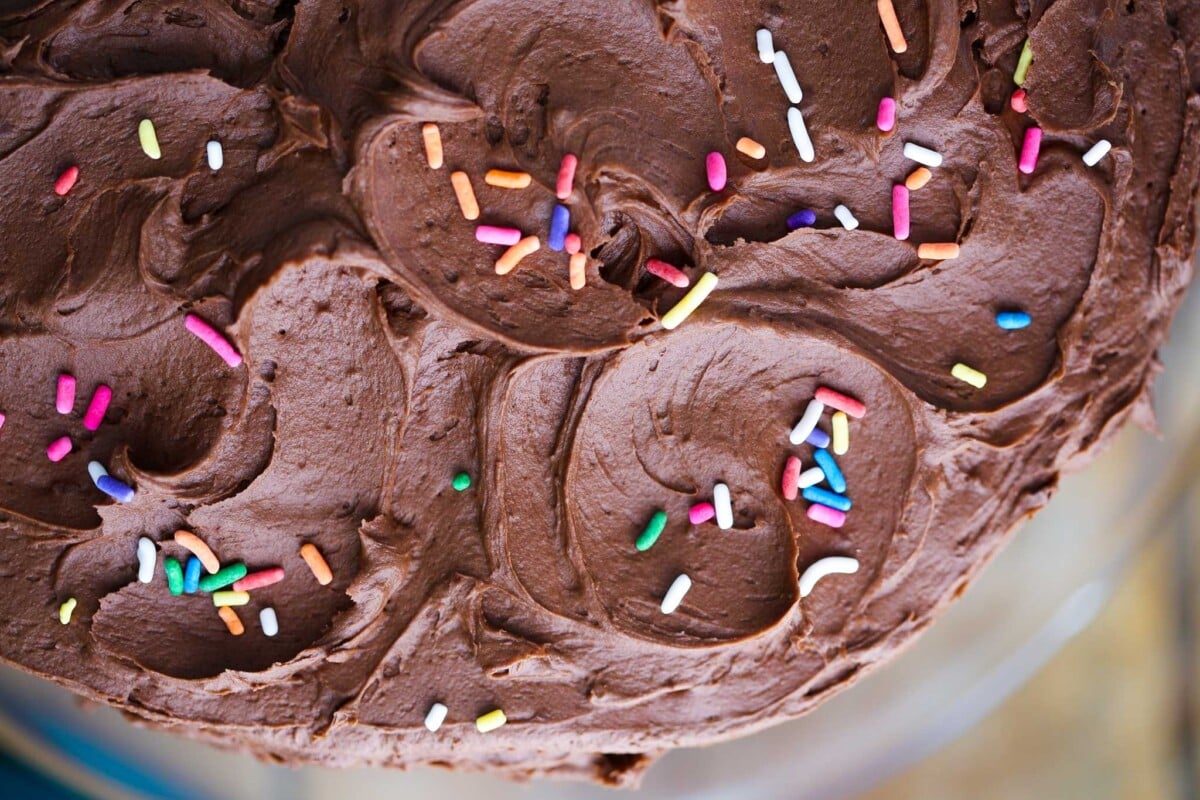 yellow cake with buttercream and rainbow sprinkles smoothed top.