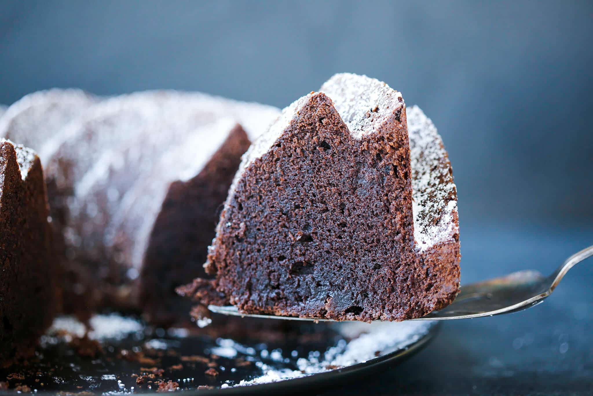 A slice of chocolate pound cake on a vintage cake server.