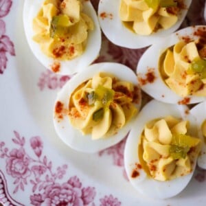 Deviled eggs arranged on a white and red plate for serving.