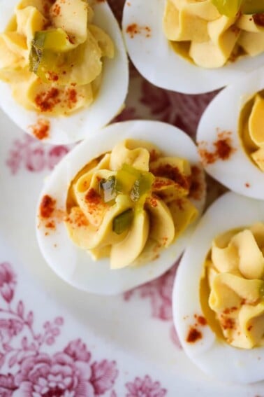 Deviled eggs arranged on a white and red plate for serving.