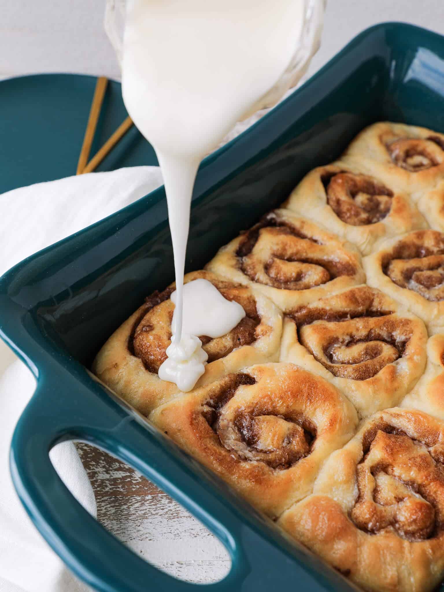 The Best Cinnamon Rolls glazing the baking dish