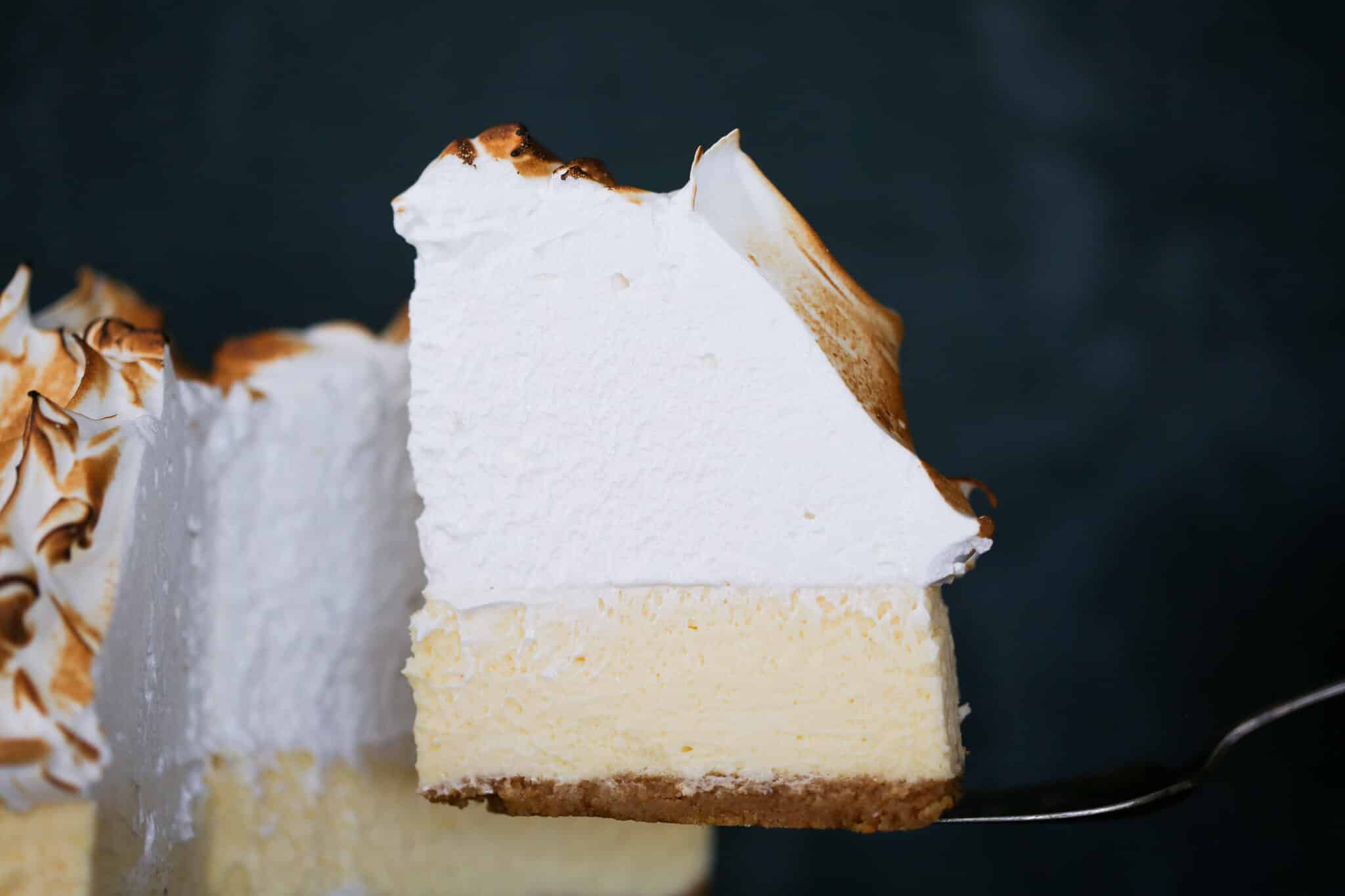 Lemon Meringue Cheesecake slice on cake server.