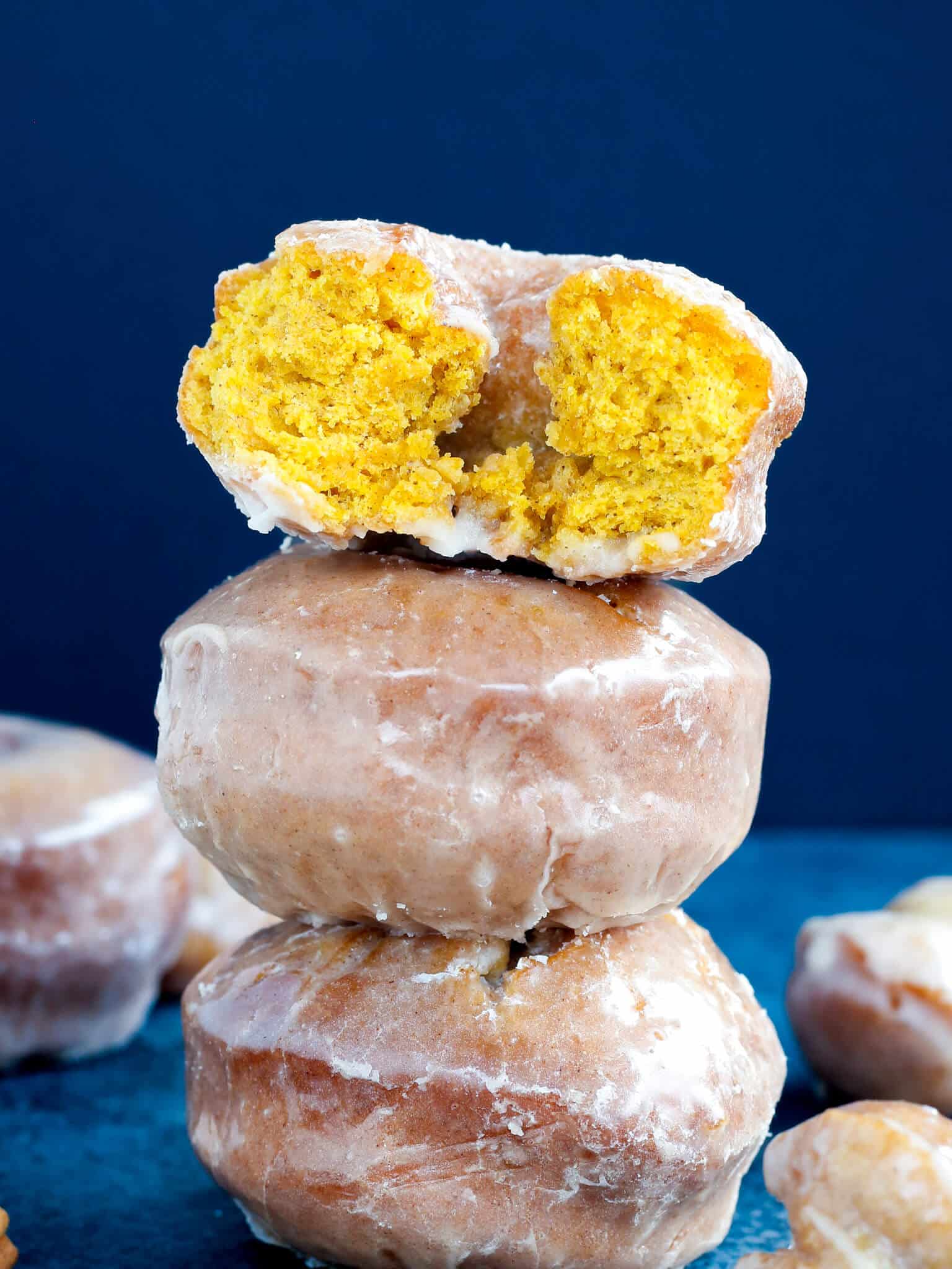 three pumpkin donuts stacked.