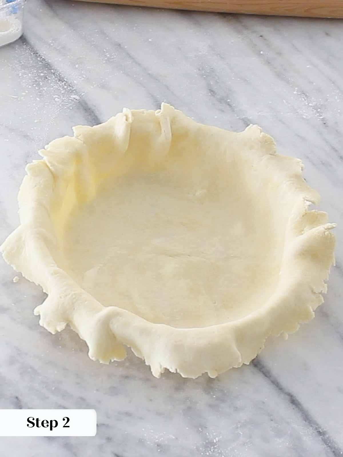 pie dough overhanging sides of pie dish.