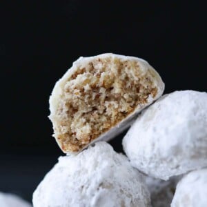 Easy Christmas cookies, pecan snowball cookies against a black backgorund.