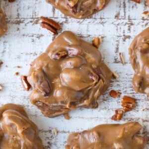A decadent brown pecan praline with on a brown slate board amid a group.