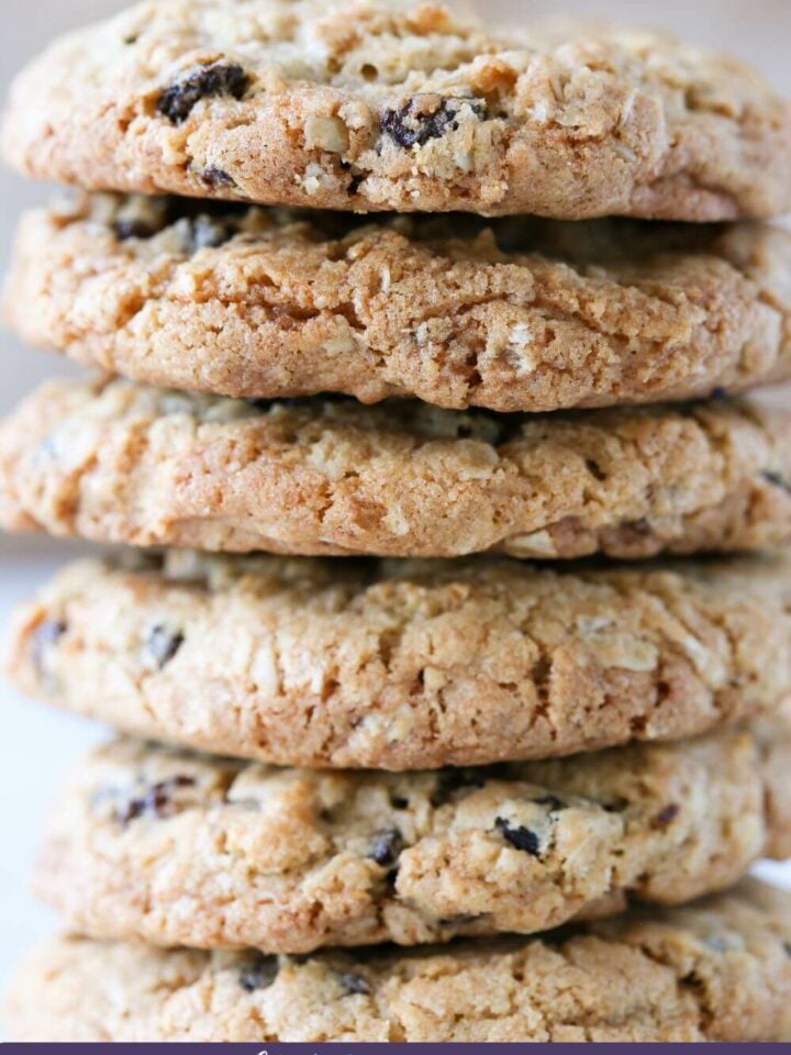 A tall stack of oatmeal raisin cookies studded with oats and raisins.