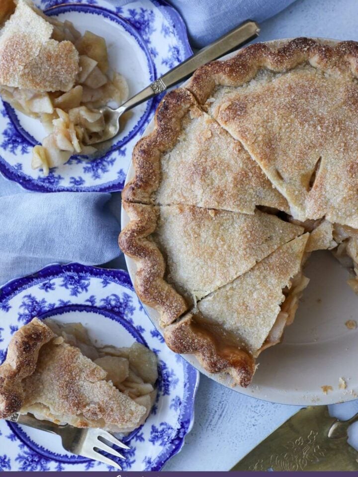 sliced apple pie with slices on blue china plates.