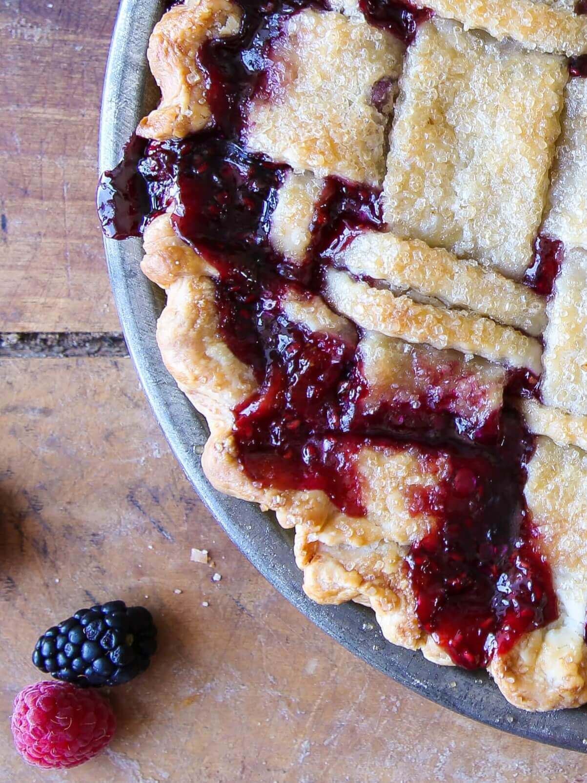 Mixed Berry Pie with dark berry filling bubbling through a lattice top.