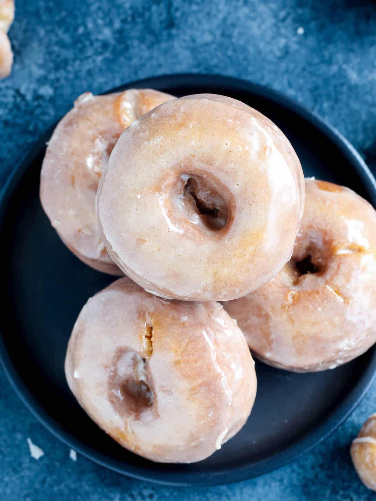 pumpkin cake donuts stacked on black plate. 