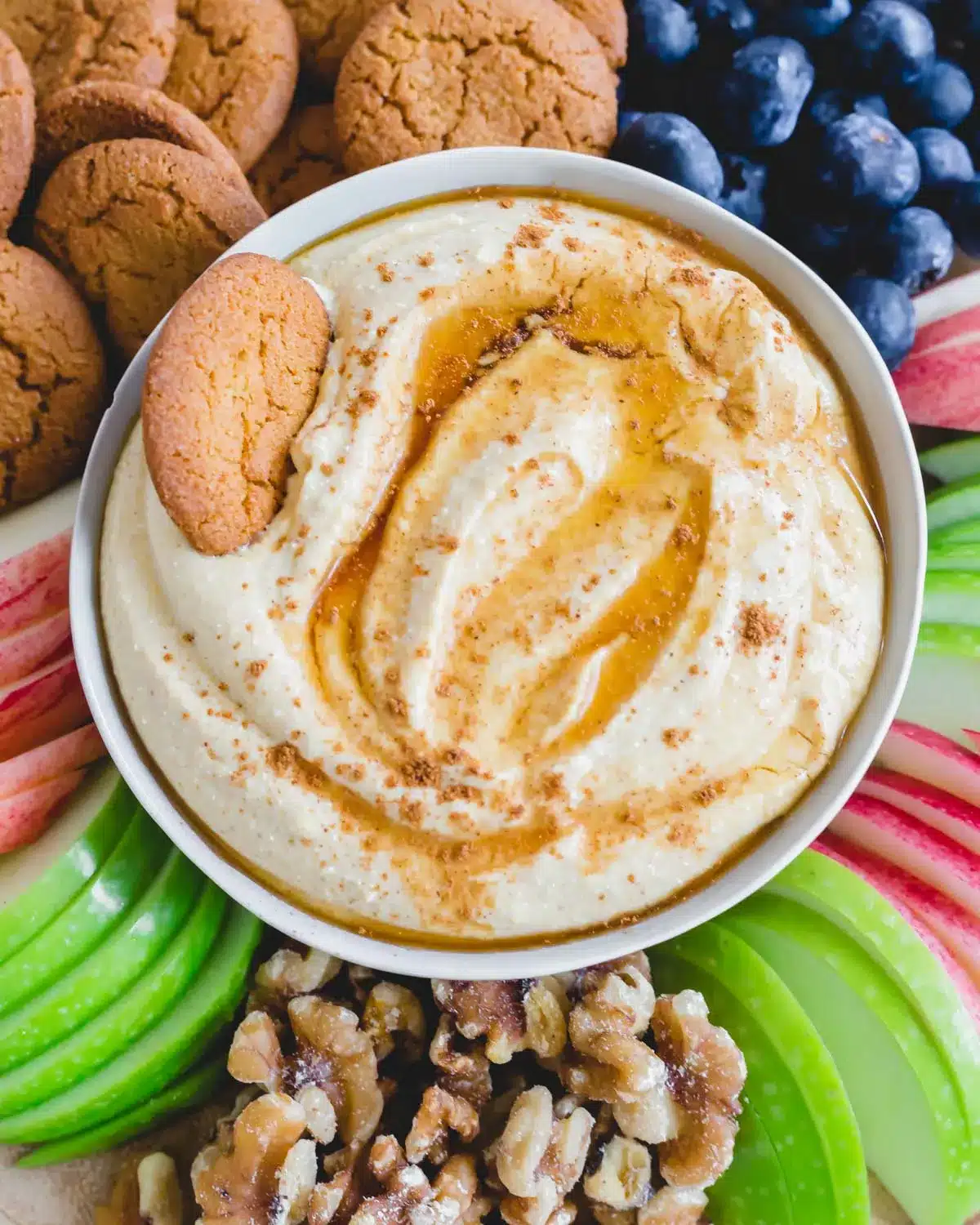 pumpkin dip in white bowl with cookie.