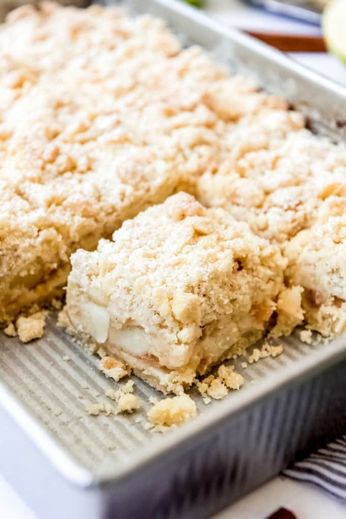 sliced german apple cake in pan with crumble.