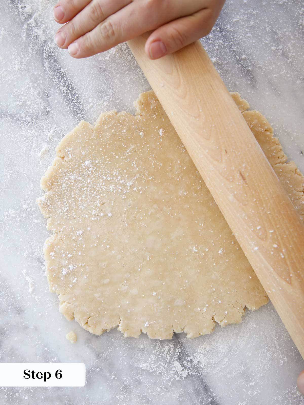 rolling crisco pie dough with wooden pin on marble