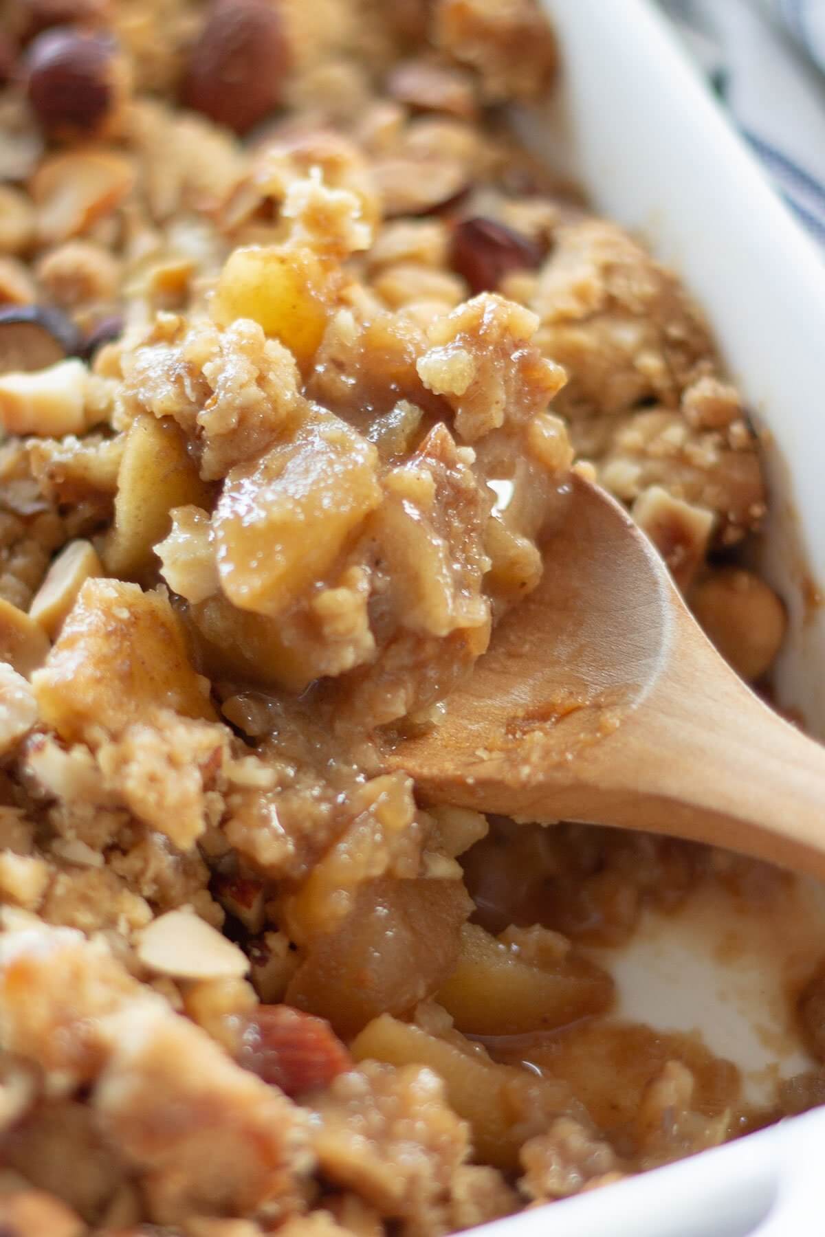 ginger spiced apple crumble on wooden spoon.