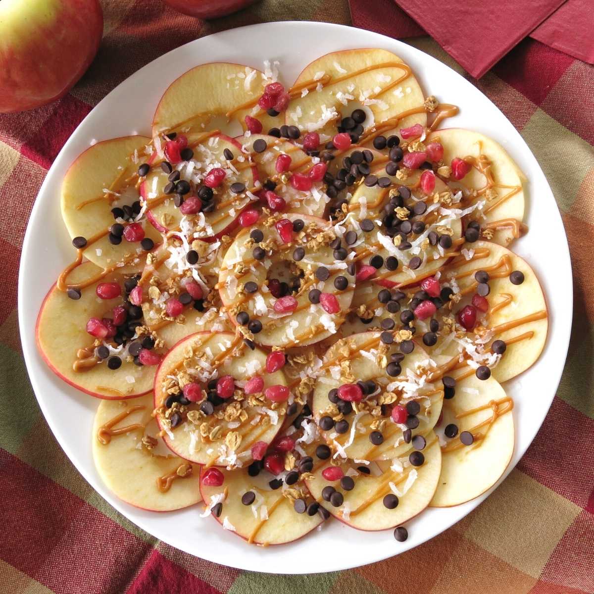 sliced apples with caramel sauce and toppings. 