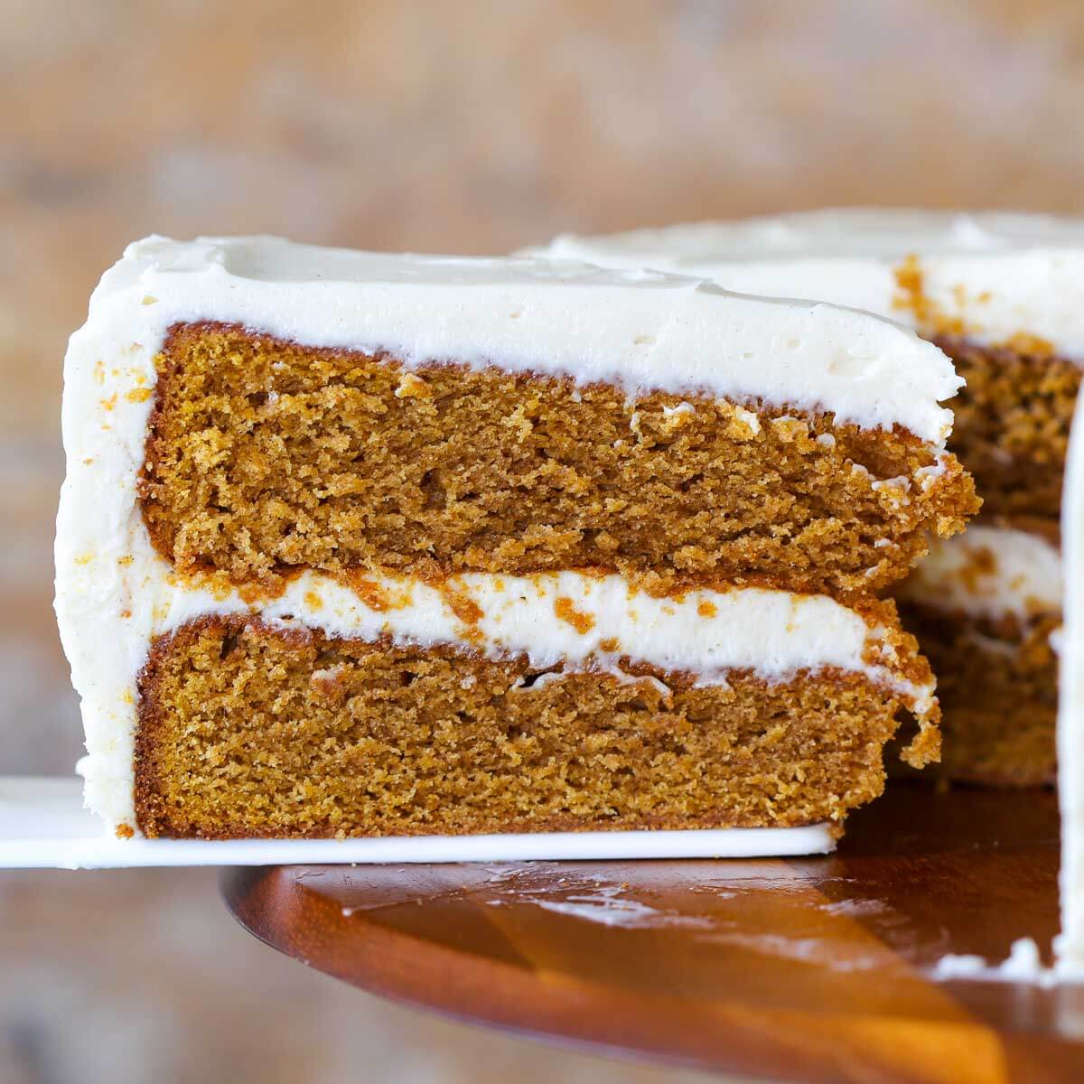 A pumpkin cake being removed from the cake with a white cake server.
