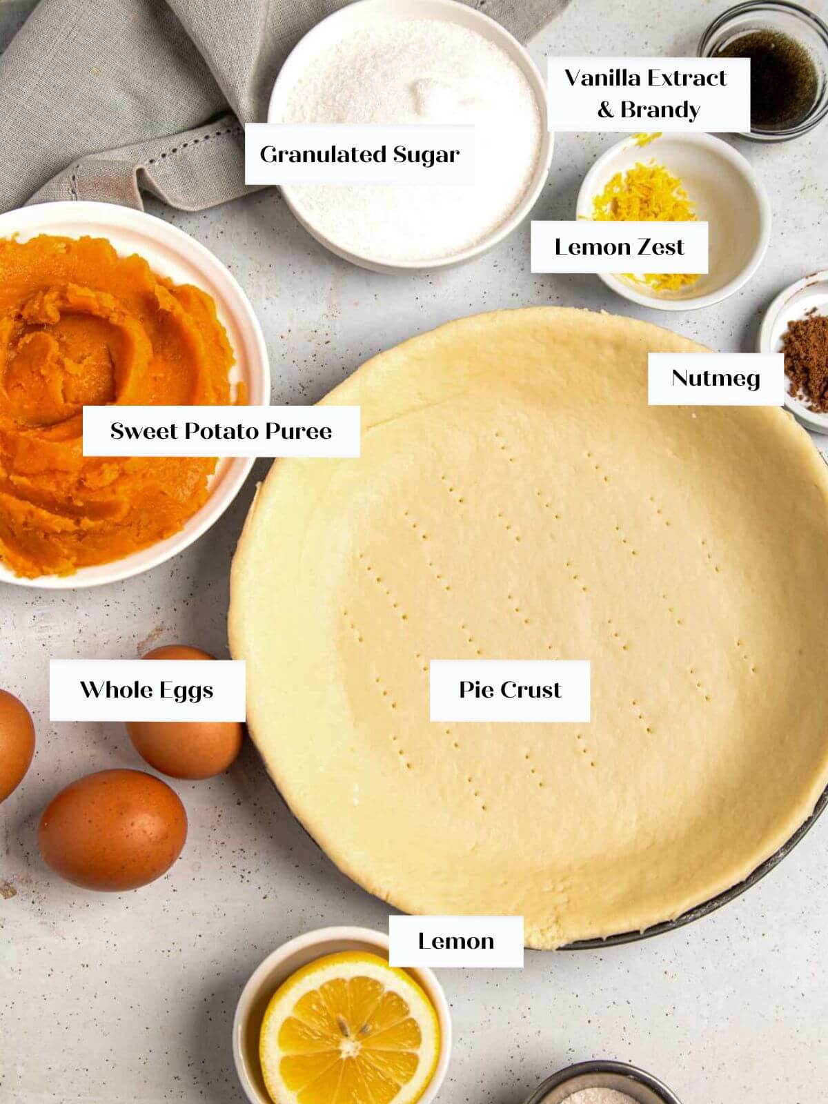sweet potato pie ingredients on white surface.