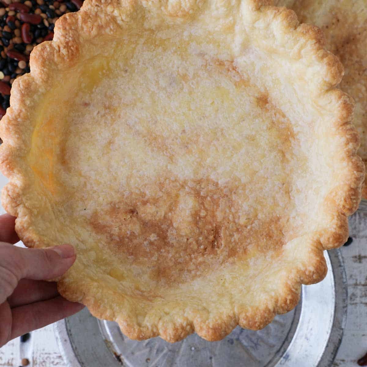 partially blind baked pie crust in hand.