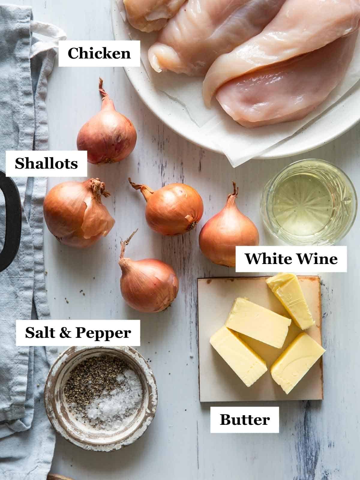 The ingredients of chicken with shallots laid out on a light background.