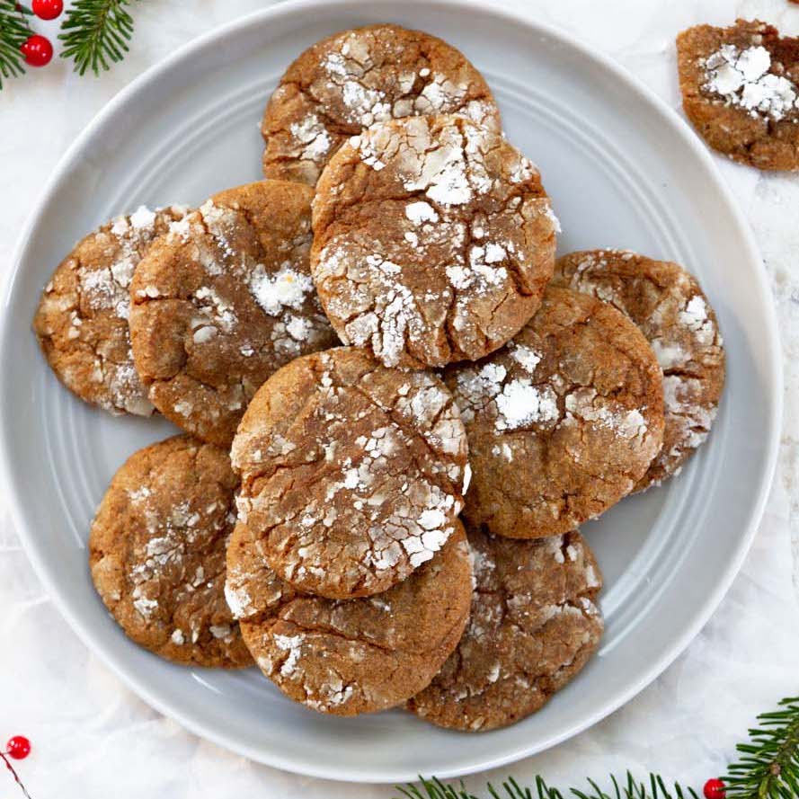 stacked gingerbread crinkle cookies on white plate.