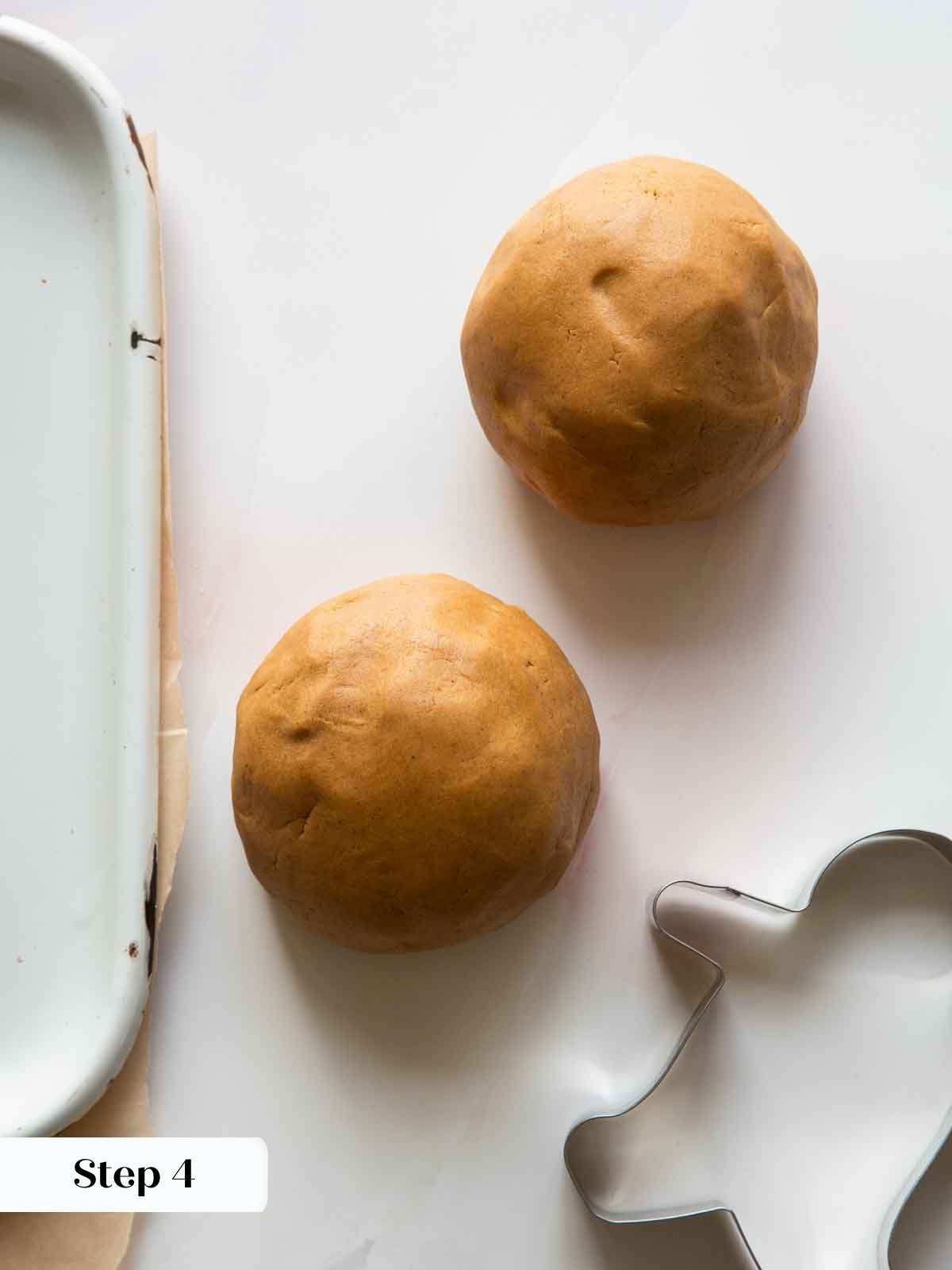 two gingerbread dough balls on countertop. 