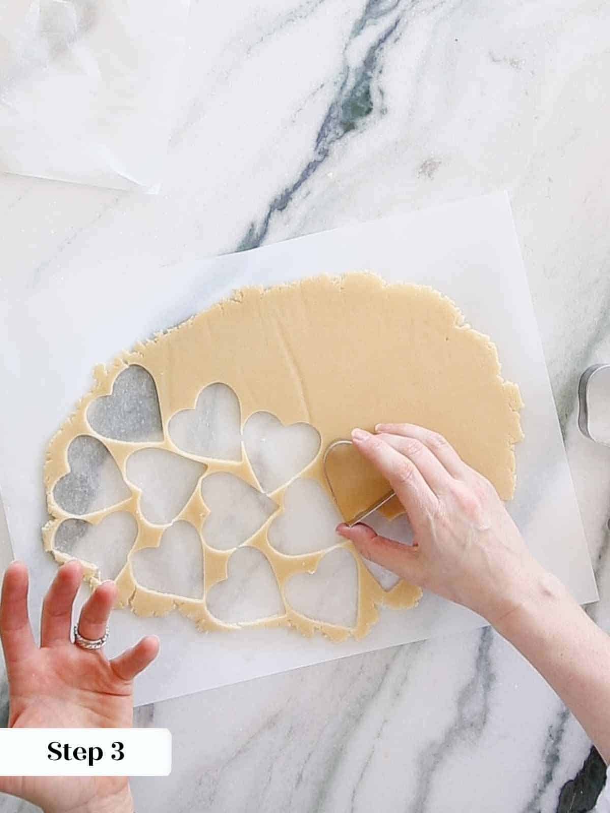 cutting sugar cookie hearts.