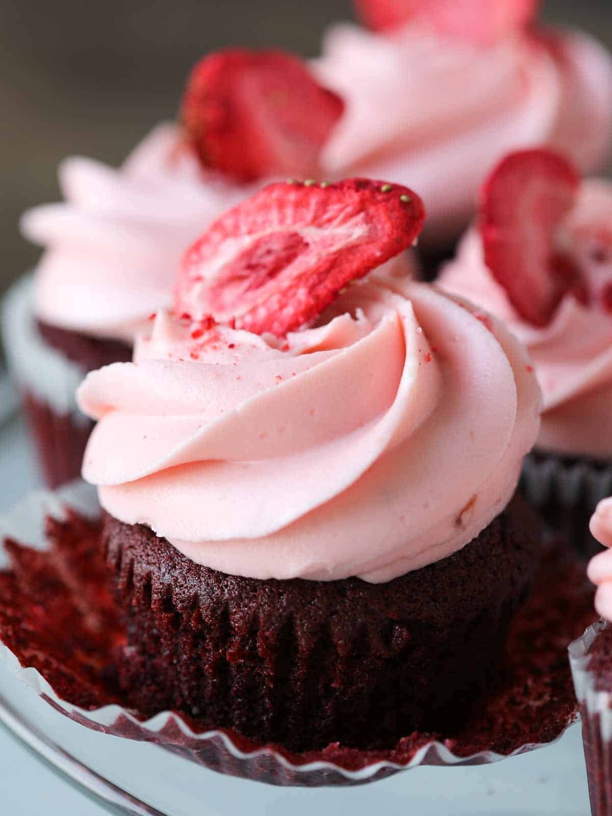 Red velvet cupcake with a peeled cupcake wrapper.
